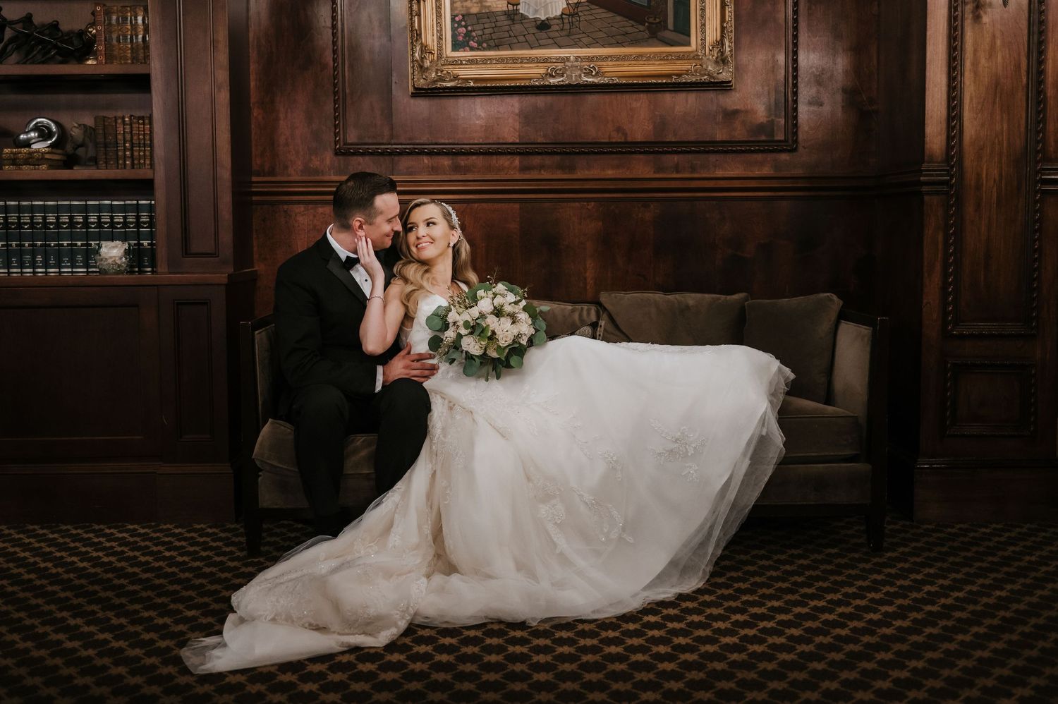 A romantic wedding couple sits together in a vintage wood-paneled room at Nanina's in the Park.