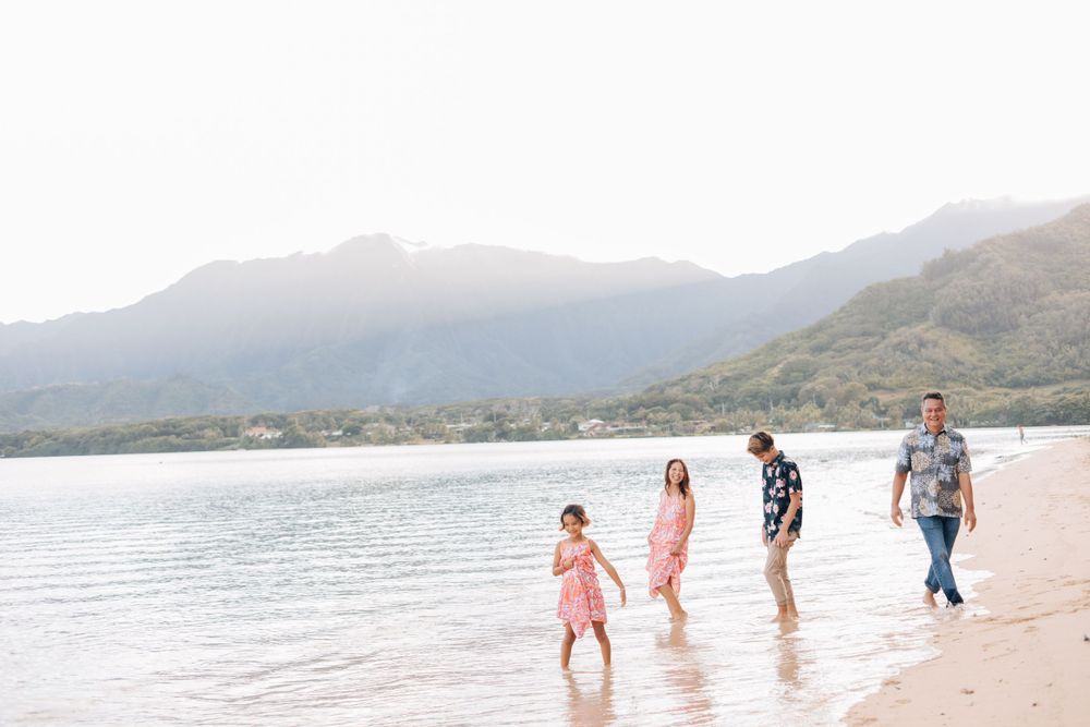 A family enjoys a casual walk along a scenic mountain beach.