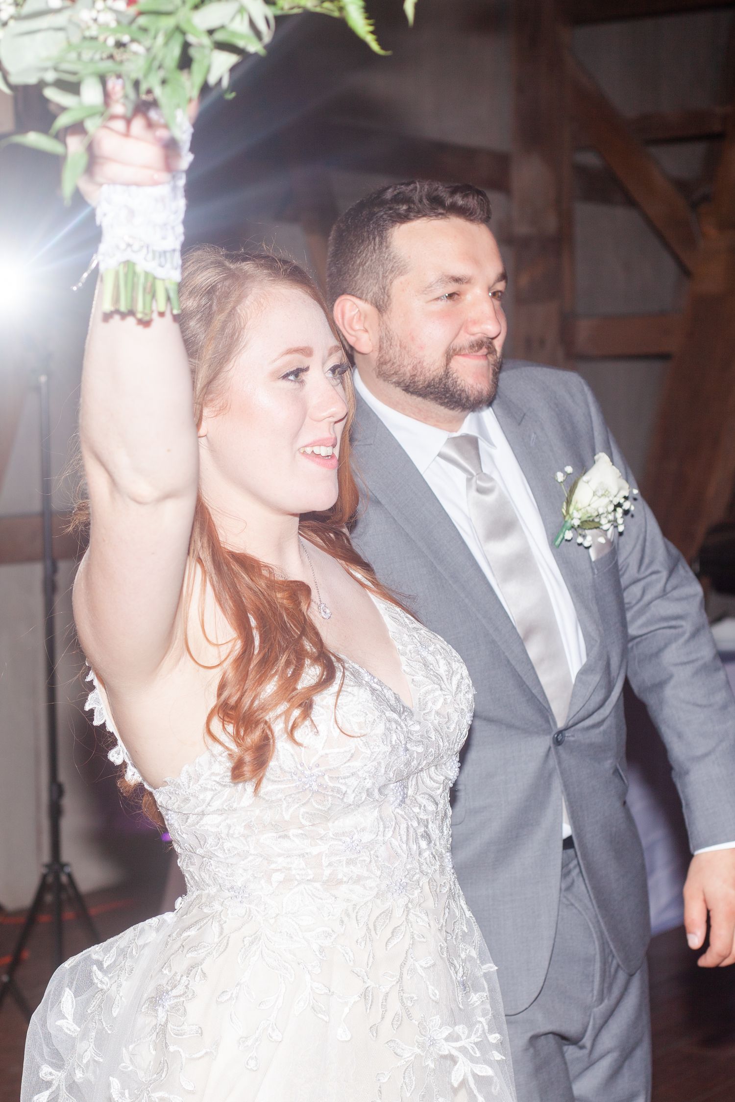 A celebratory dance moment at an indoor wedding reception with white decor.