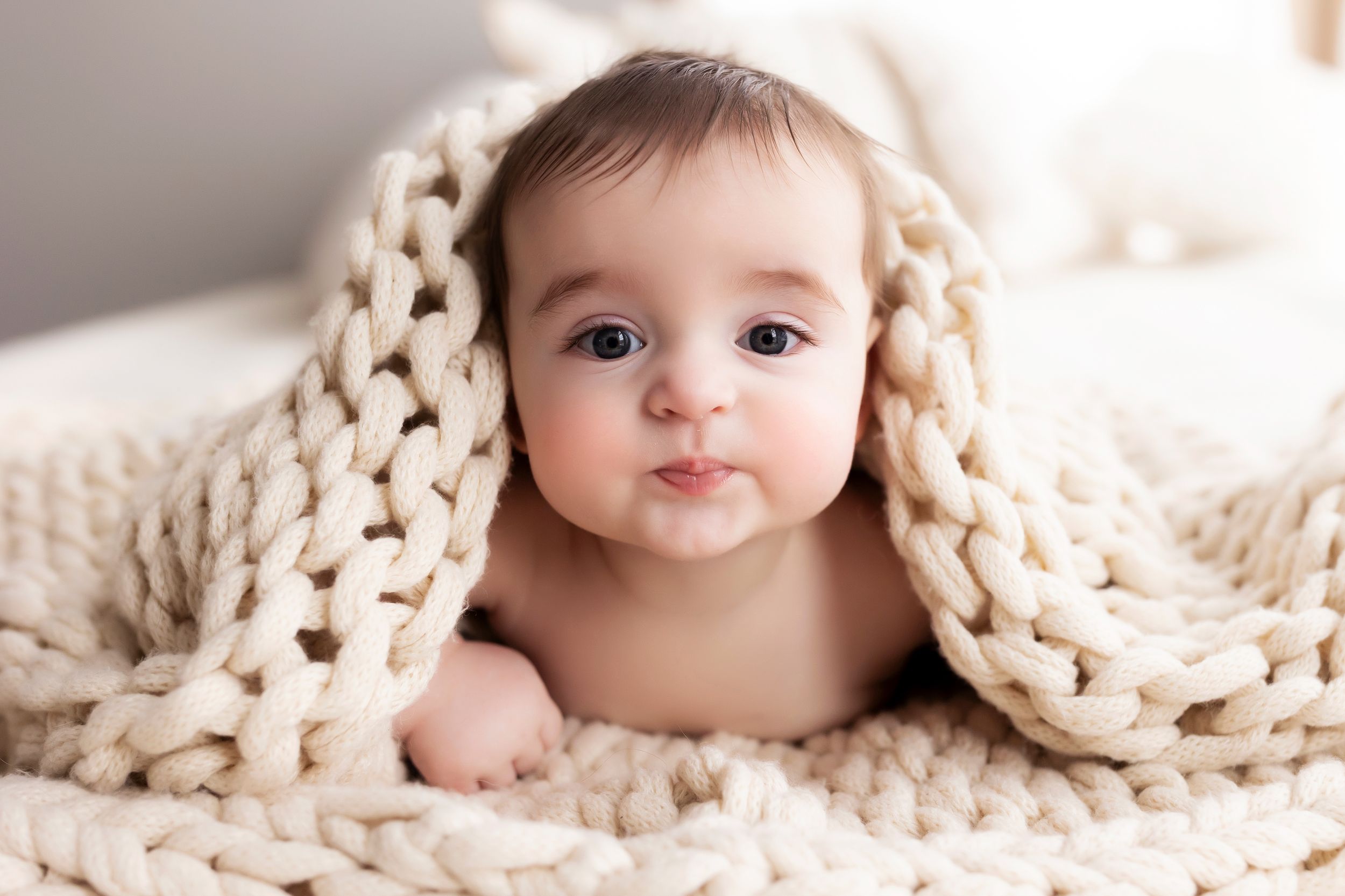 Baby photography with chunky cream knit blanket in close-up shots.