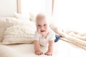 Baby portrait series with white knit blankets and cream colored background.