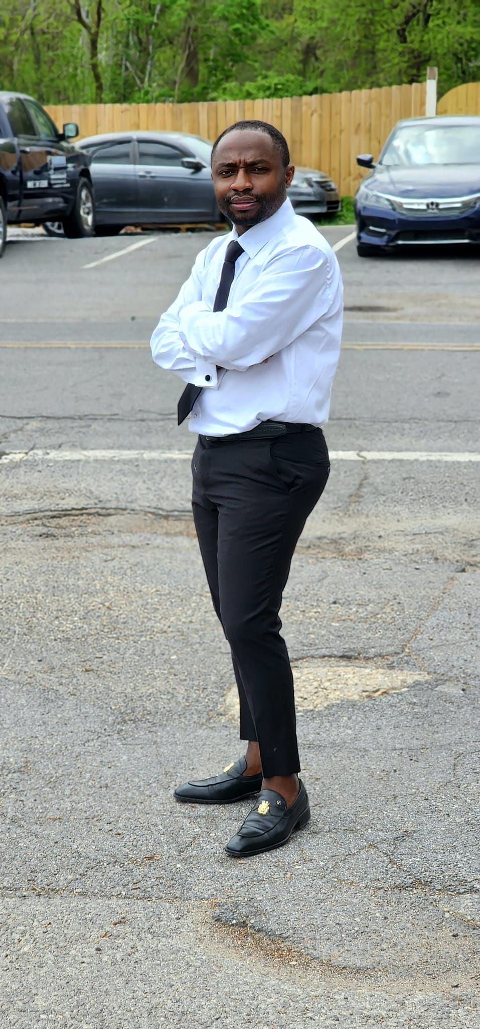 Professional portrait of businessman in white shirt and tie standing in parking lot.