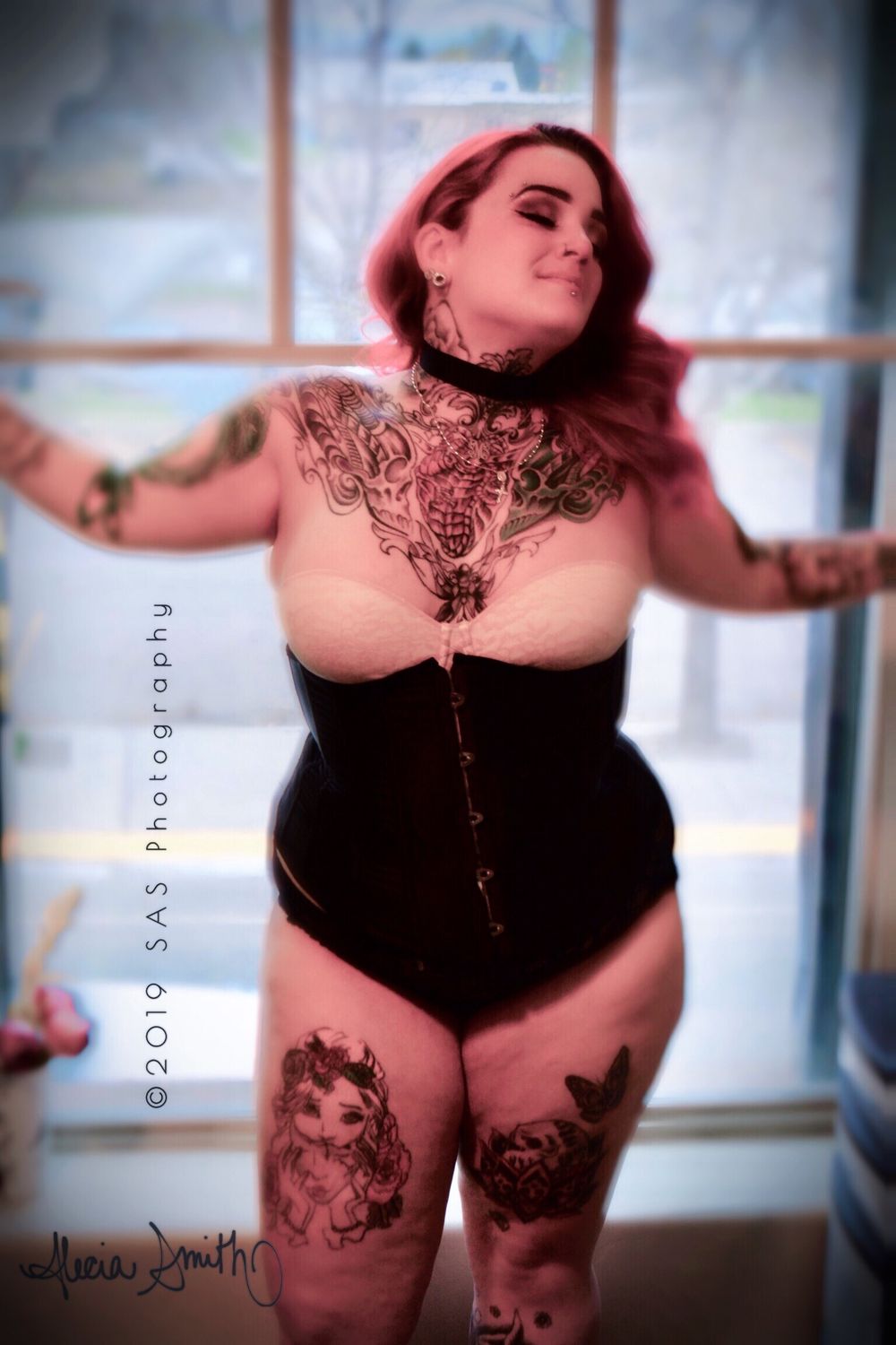 Artistic boudoir photo showing person in black lingerie with decorative body art.