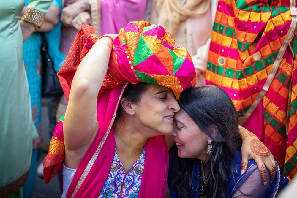 Vibrant celebration with guests in colorful traditional Indian attire sharing a joyful moment.