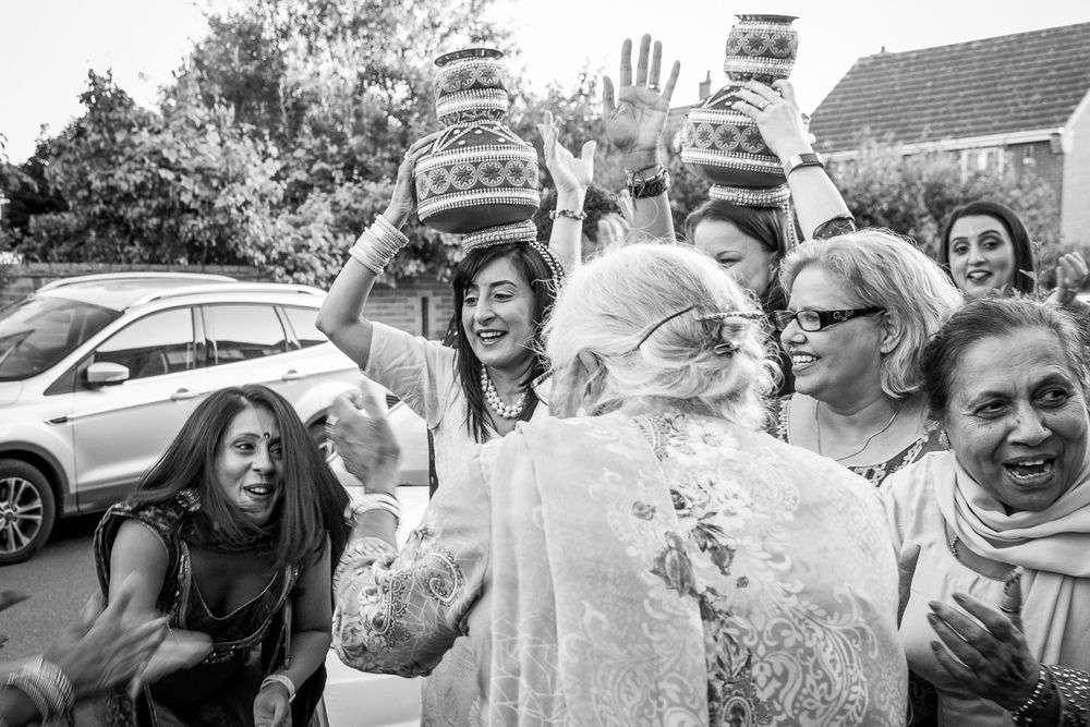 Energetic black and white photo of wedding guests celebrating outdoors.