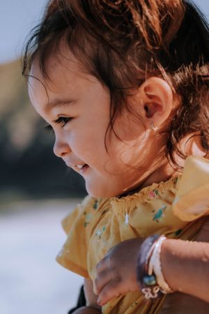 Close-up profile view showing joy and laughter in yellow ruffled clothing.