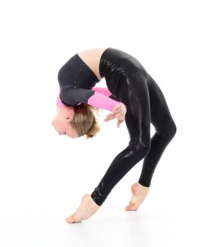 Flexible dancer in black leggings performing backbend pose against white background.