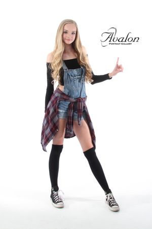 Modern dance pose in casual outfit with denim and plaid against white background.