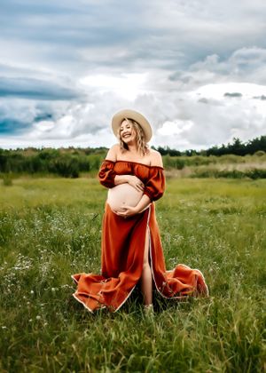 A maternity session in a field in Orlando, FL. Mom is wearing a two piece dress to show her baby bump.