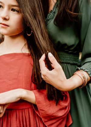A mom running her fingers in her daughter's hair during a family session in Orlando, FL.