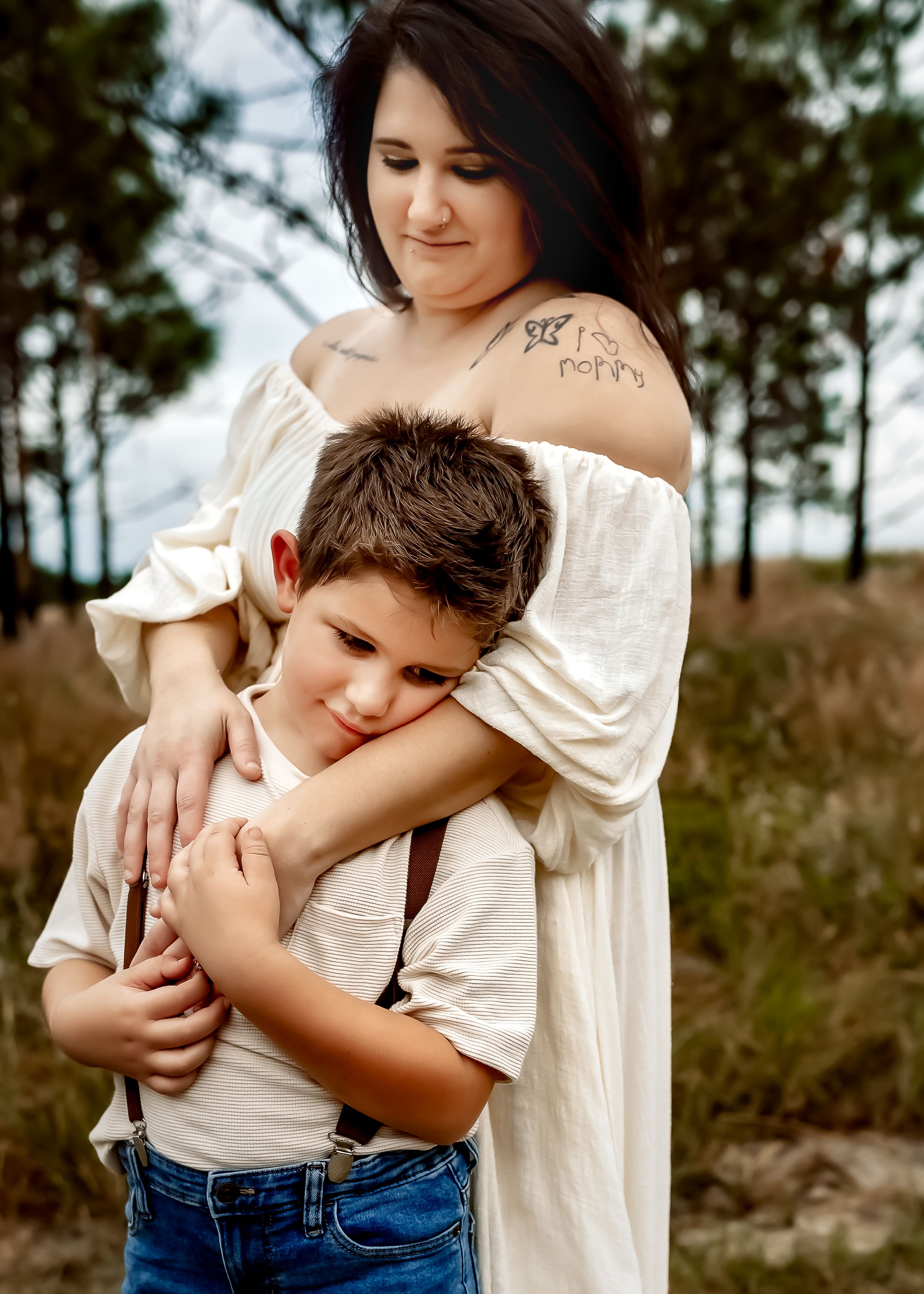 A mom and son cuddling during a family session in Orlando, FL. Mom has tattoos.