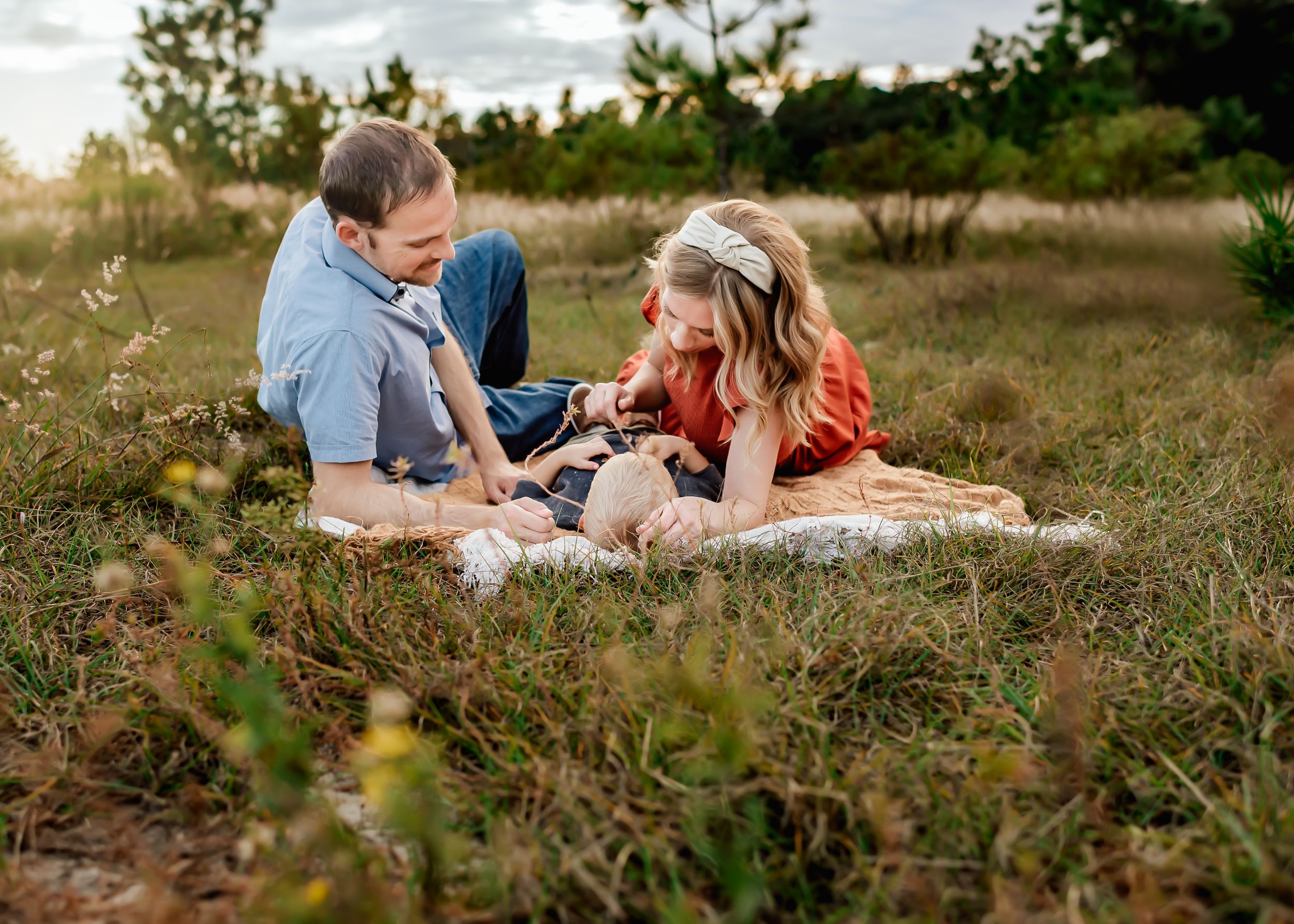 A family cuddling on a blanket during outdoor family session in Orlando, FL.