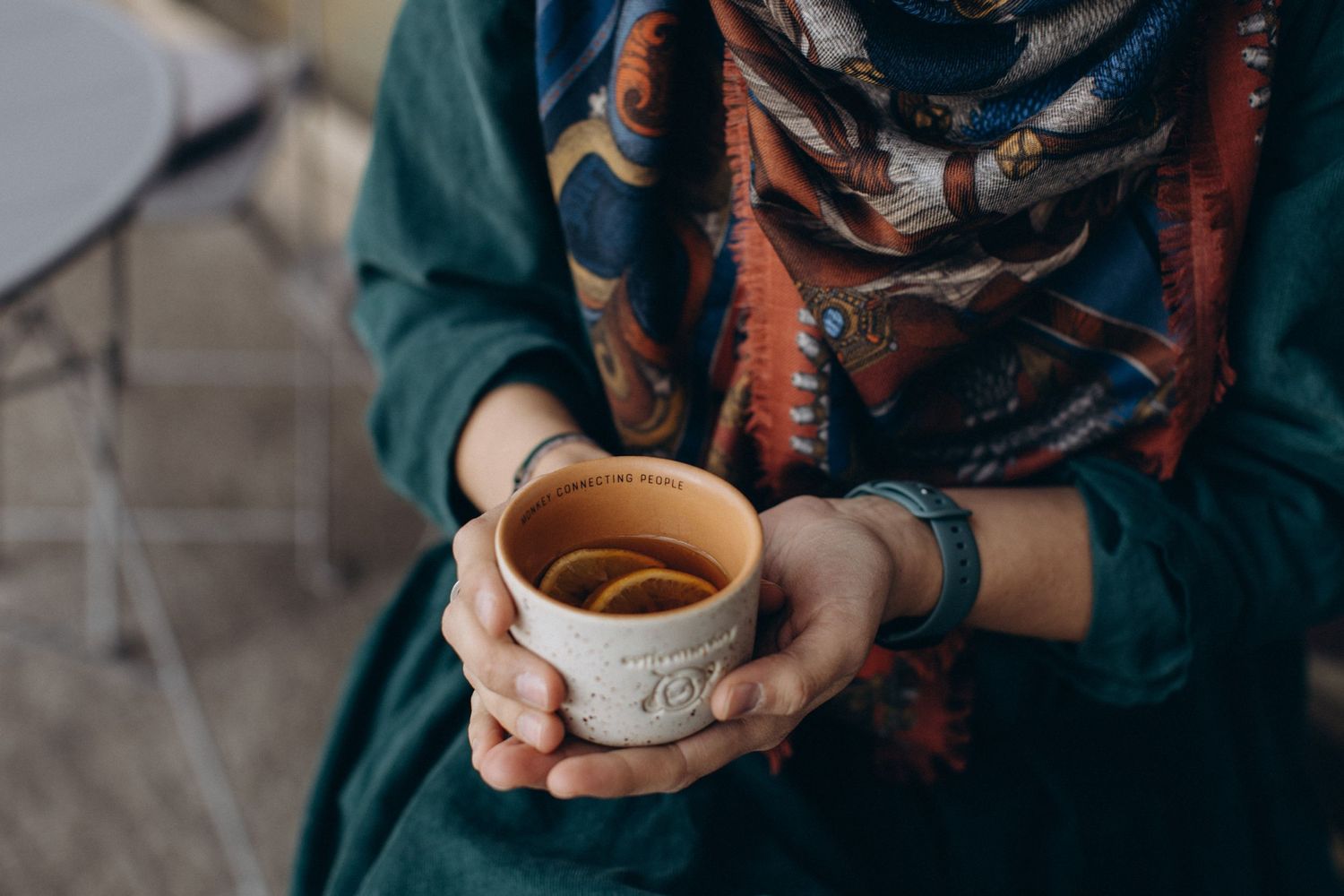Camelia Graur holding a cup of coffee with a writing, that says Connecting People