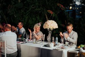 Wedding reception dinner table with elegant floral centerpiece and evening lighting.