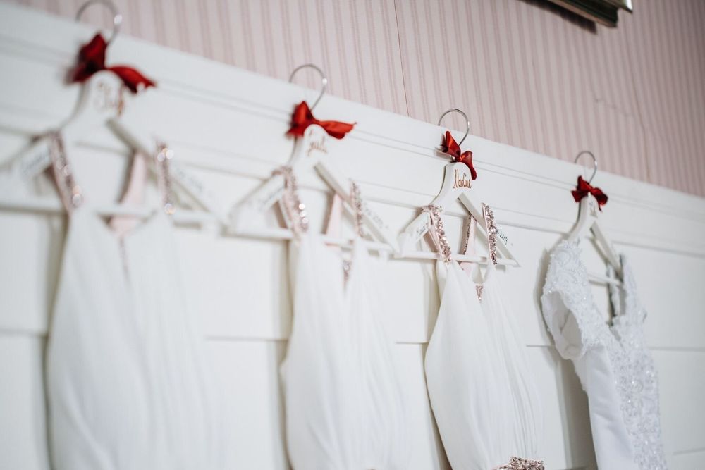 Elegantes Brautkleid neben den Kleidern der Brautjungfern, kunstvoll arrangiert.