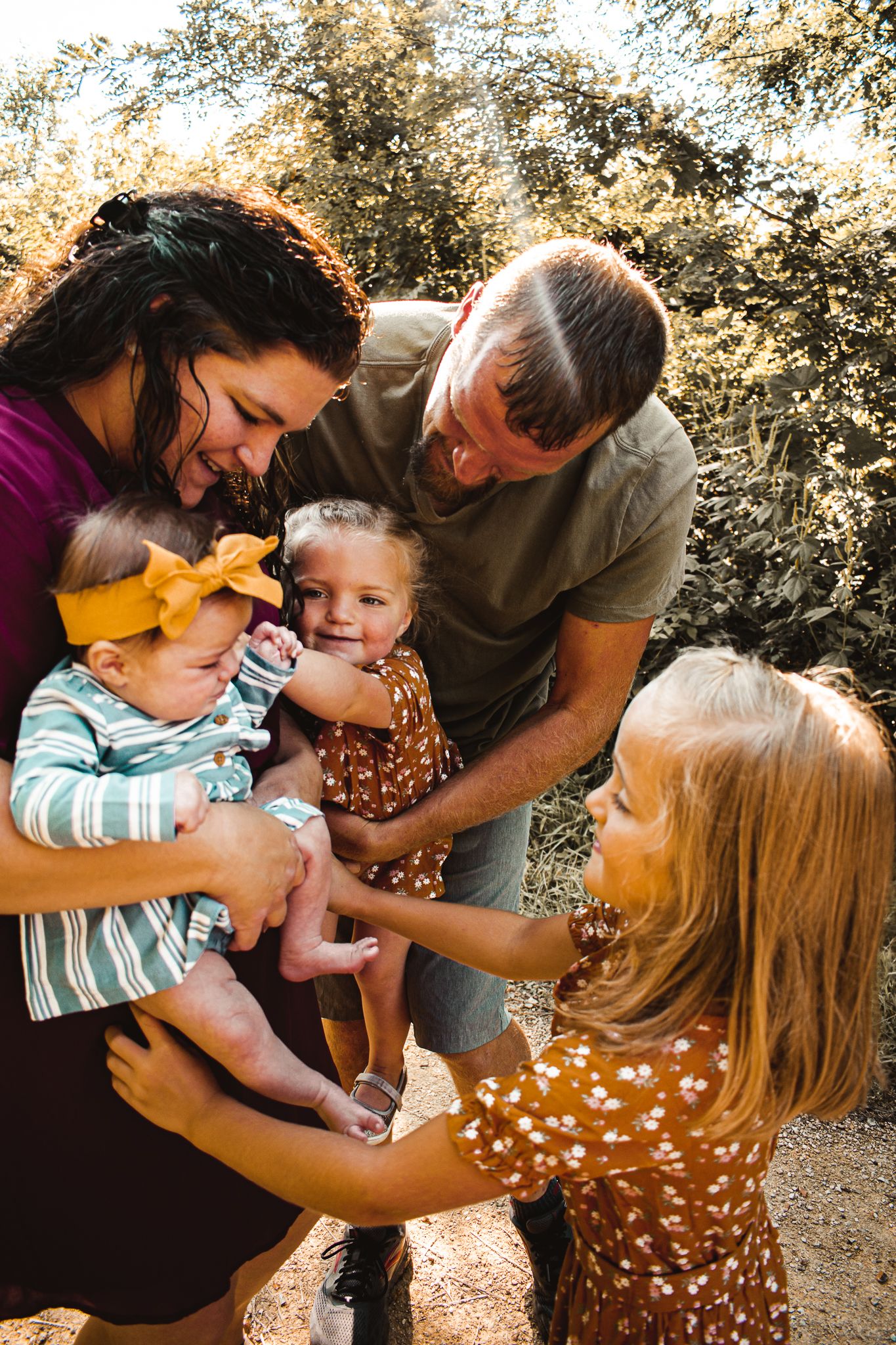 Family shares joyful moment together outdoors in warm sunlight.