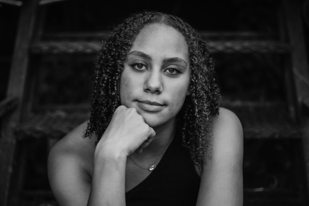Dramatic black and white portrait with moody lighting and shadows.