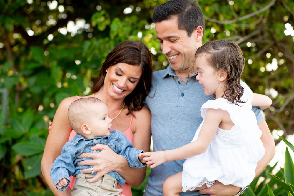 A happy group shares a tender moment together outdoors with bokeh lights in the background.
