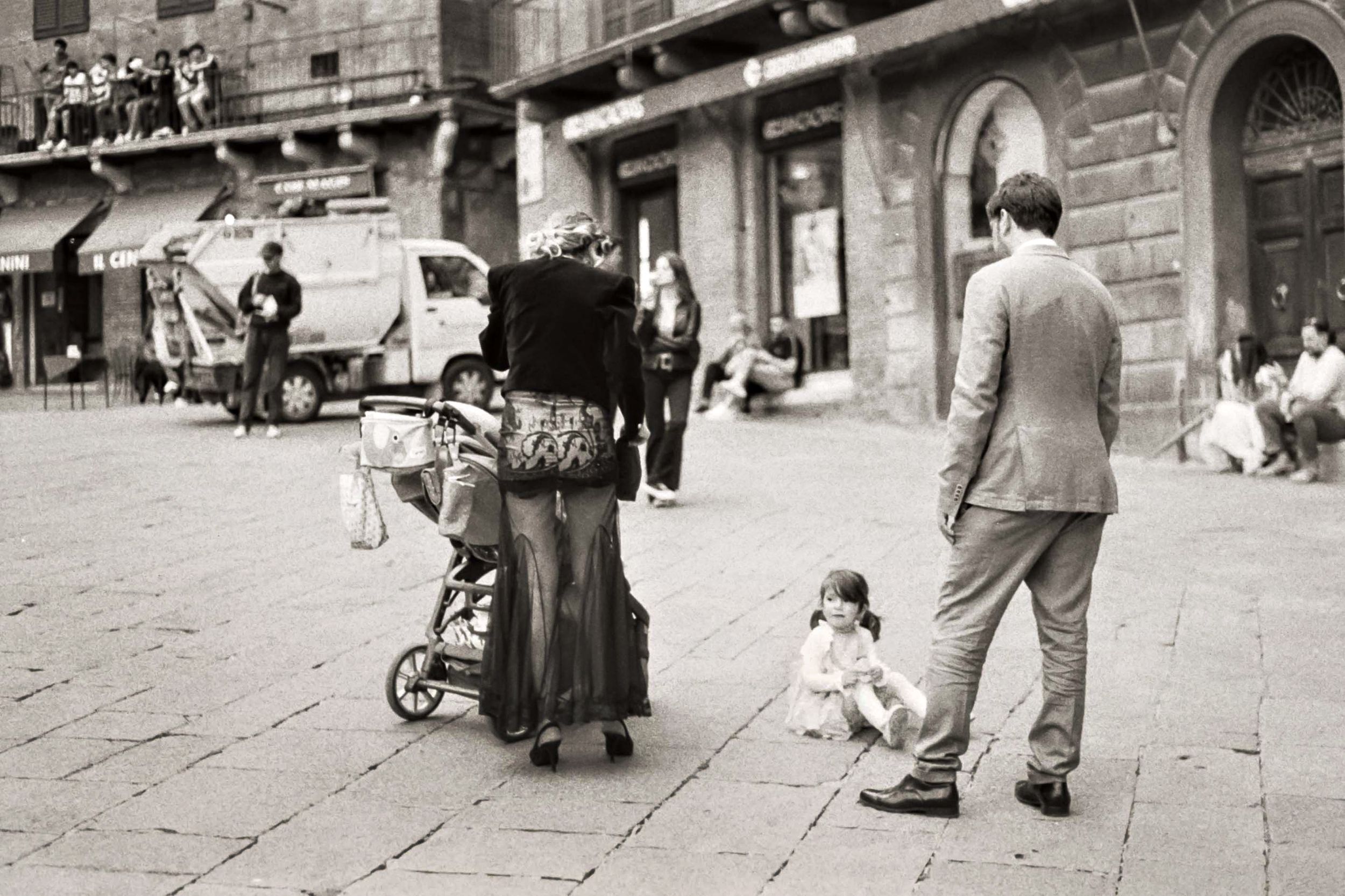 Nostalgic black and white photograph of people walking on an old city street.