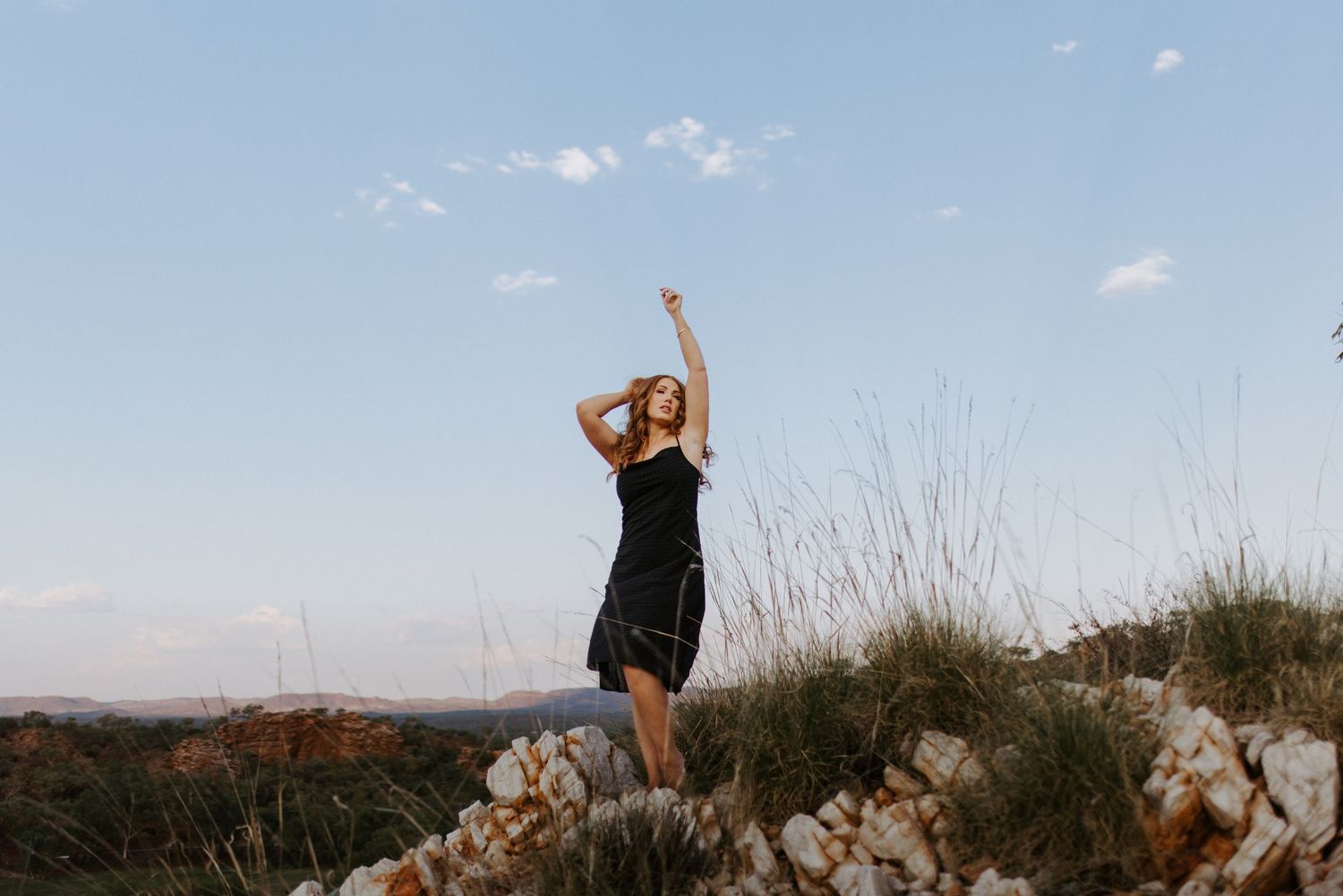 Beautiful portrait photography of woman on cliff embracing the wind at Lake Moondarra, Mount Isa