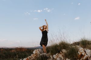 Beautiful portrait photography of woman on cliff embracing the wind at Lake Moondarra, Mount Isa