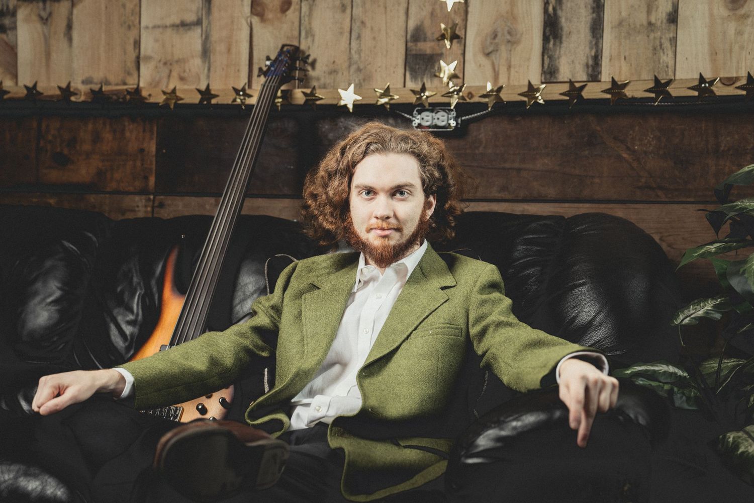 Man sitting on couch next to guitar