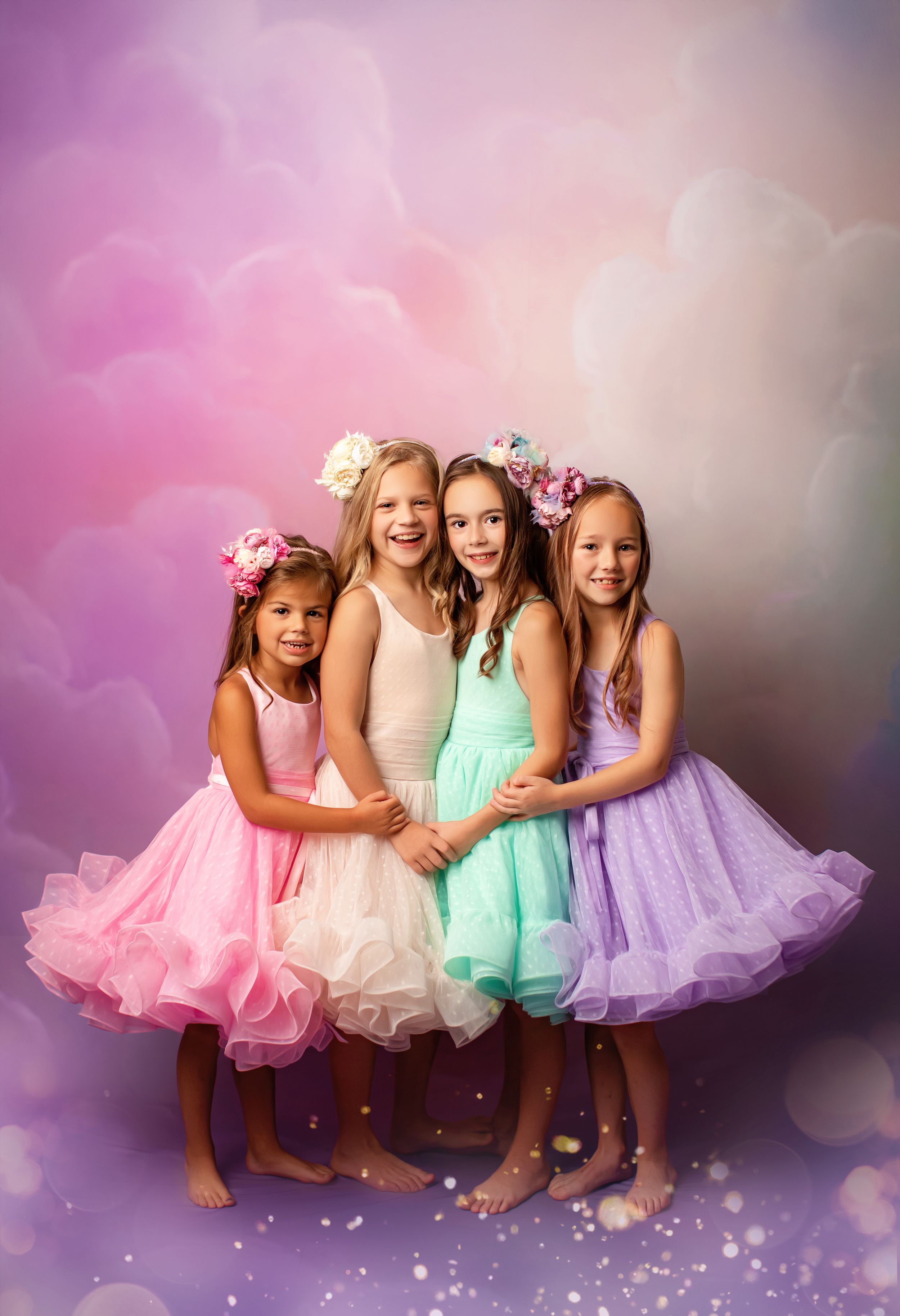 Group portrait in pastel tulle dresses against dreamy purple background.