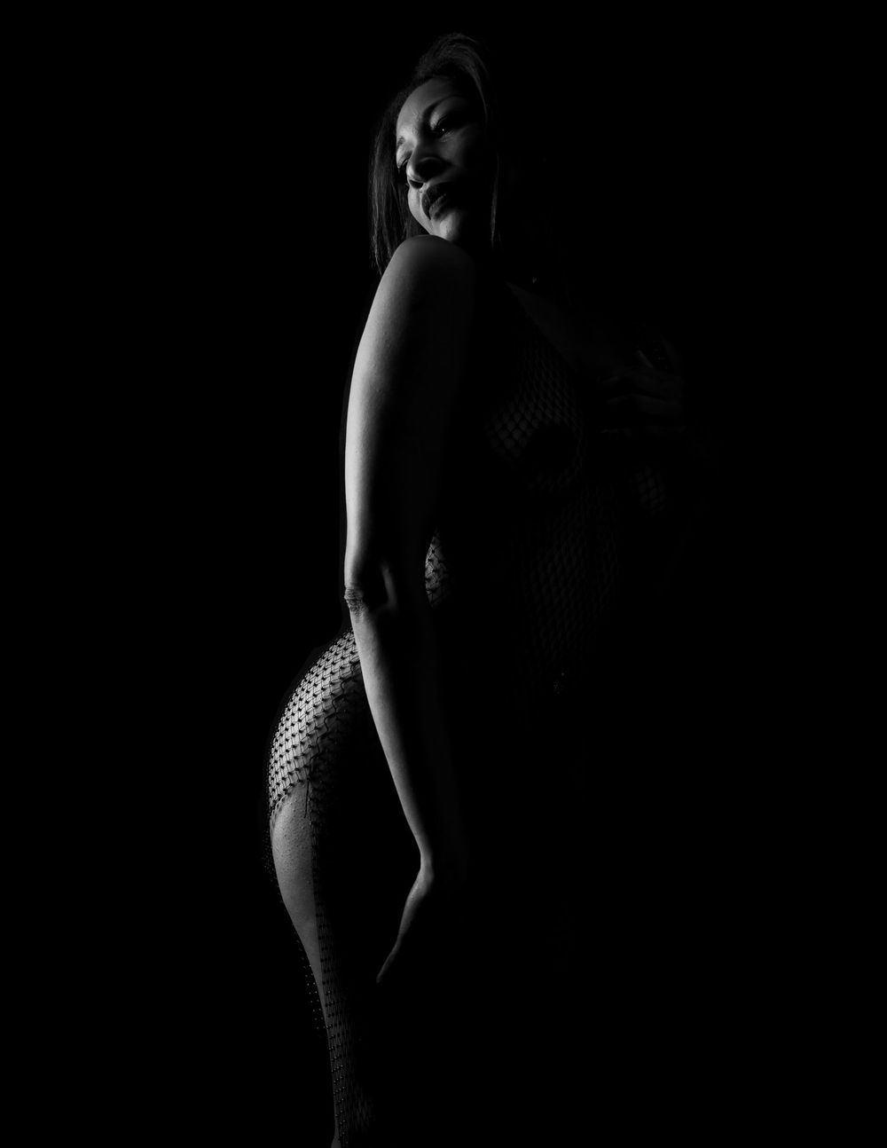 Minimalist black and white silhouette study with dramatic side lighting.