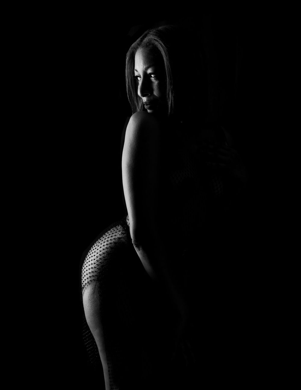 High contrast black and white artistic portrait with strong rim lighting.