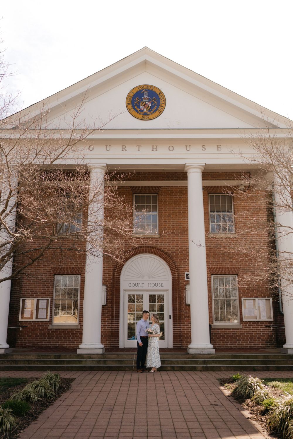 The front facade of a courthouse with tall white columns and a state seal above the entrance.