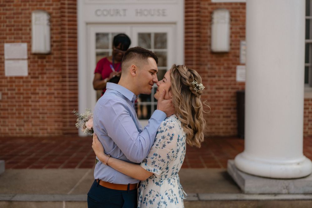 An intimate close-up shot of a couple sharing a moment at the courthouse entrance.