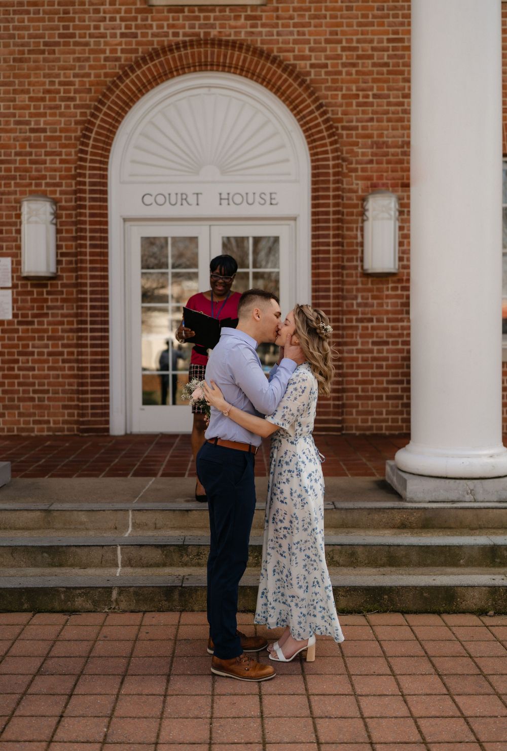 A tender moment captured in front of the courthouse's arched entrance and columns.