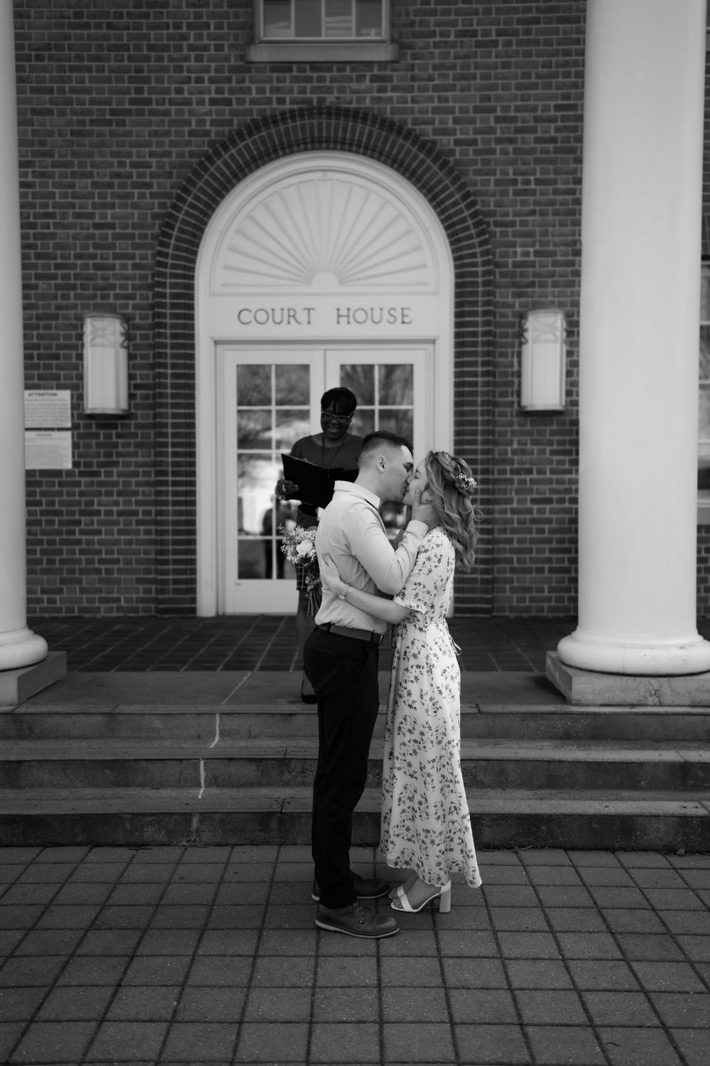 A black and white photograph of a romantic moment on the courthouse steps.