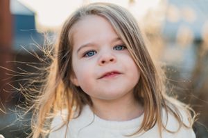 A close-up portrait series shows a young child with brown hair in natural outdoor backlighting at sunset.