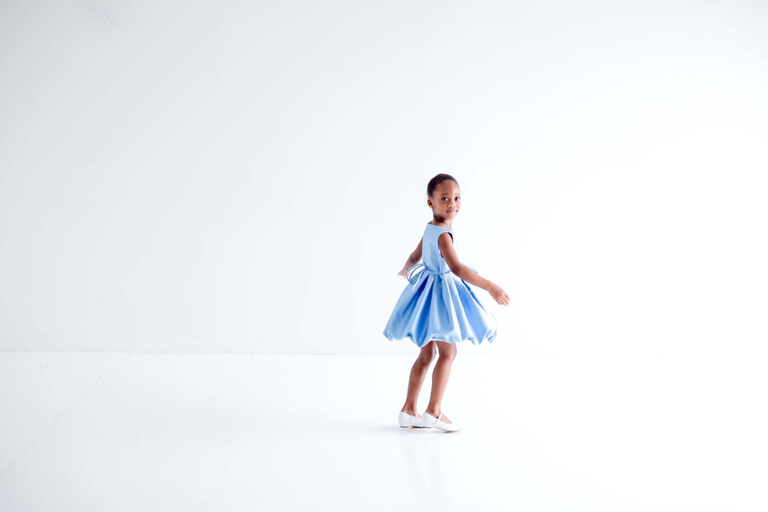 african american girl dancing in a white all natural light studio