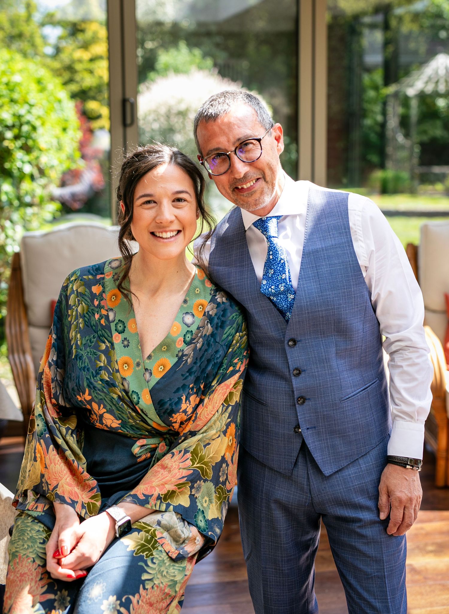 Candid moments in a sunlit garden setting with elegant attire.