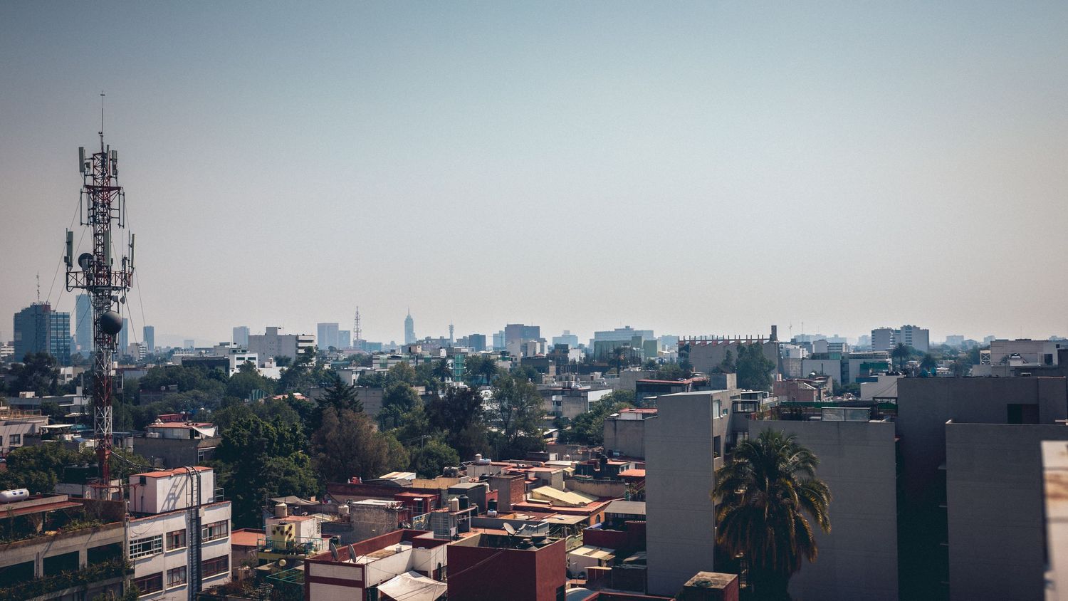 Urban cityscape view with telecommunications towers and buildings.