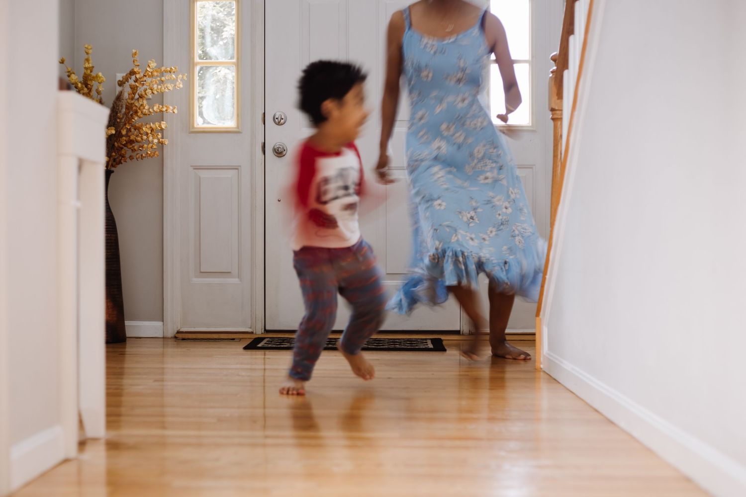blurry image of a kid and women playing in the house and laughing