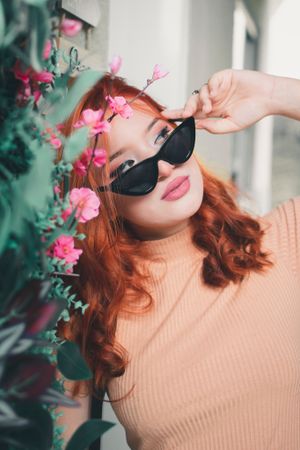 Romantic fashion photo featuring cat-eye sunglasses and delicate pink flowers.