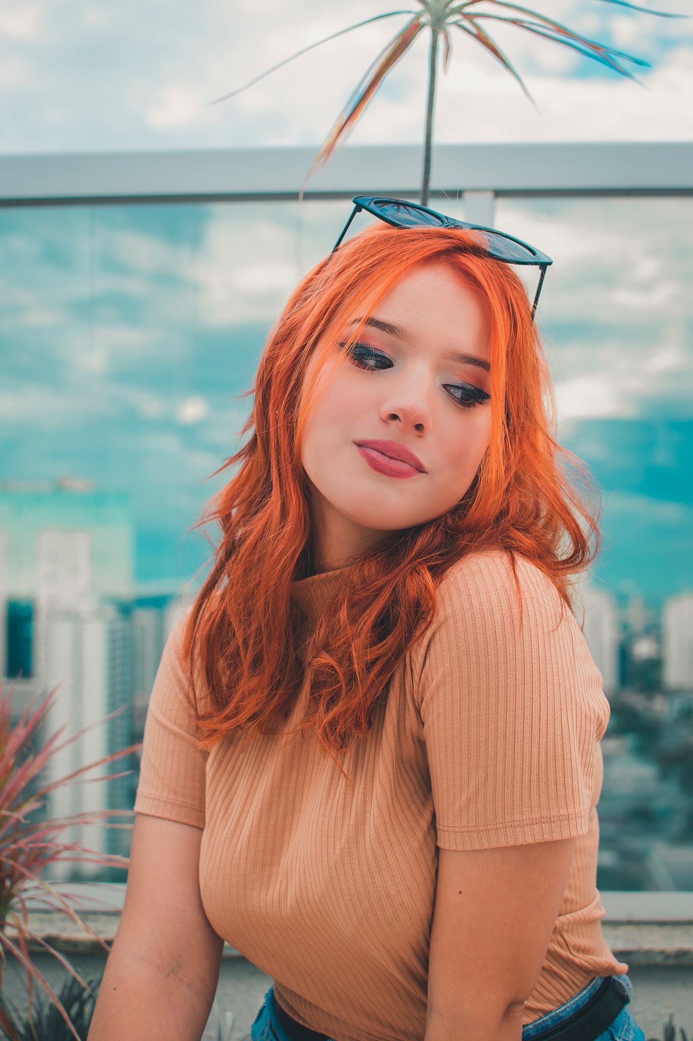 Stylish portrait against city skyline with distinctive palm plant decor.