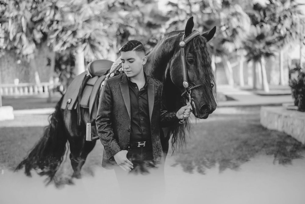 quinceanero posing in front of the horse. McAllen wedding photographers