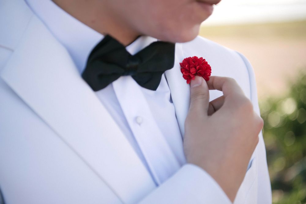 boy holding a boutonniere at his photo shoot at south padre island. McAllen wedding photographers