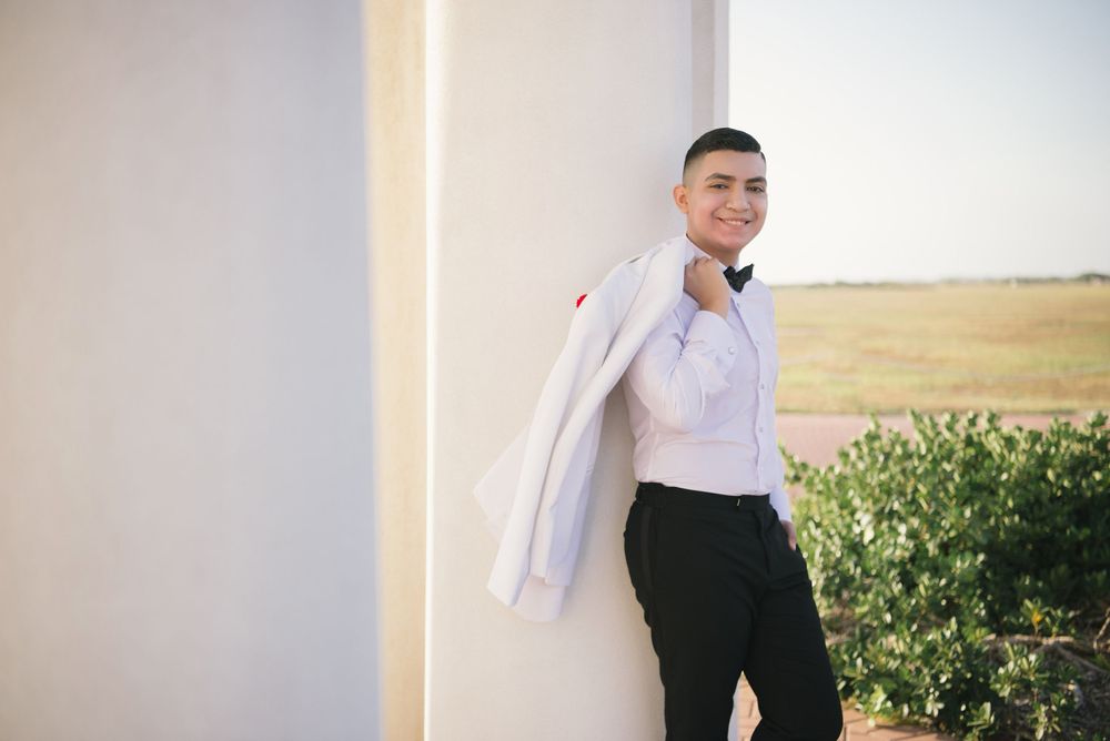 boy holding a jacket one hand leaning on a column. south padre island, texas