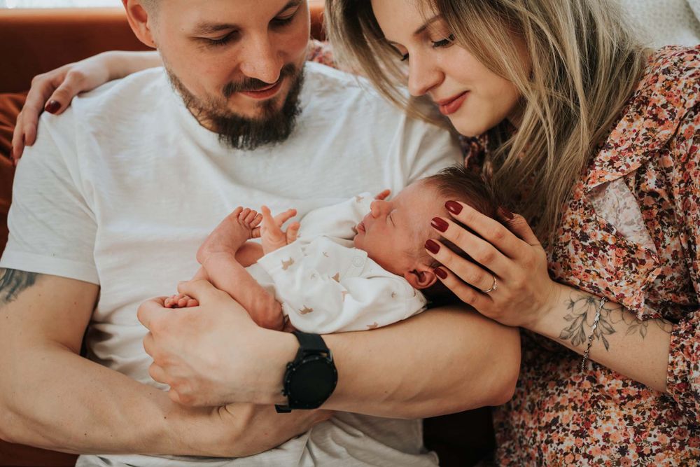 dziecko w ramionach mamy i taty - fotograf noworodkowy Kraków
