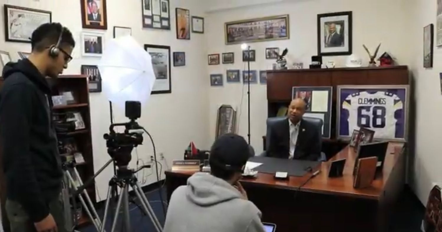 Professional video studio setup with lighting equipment and framed photos on the wall.