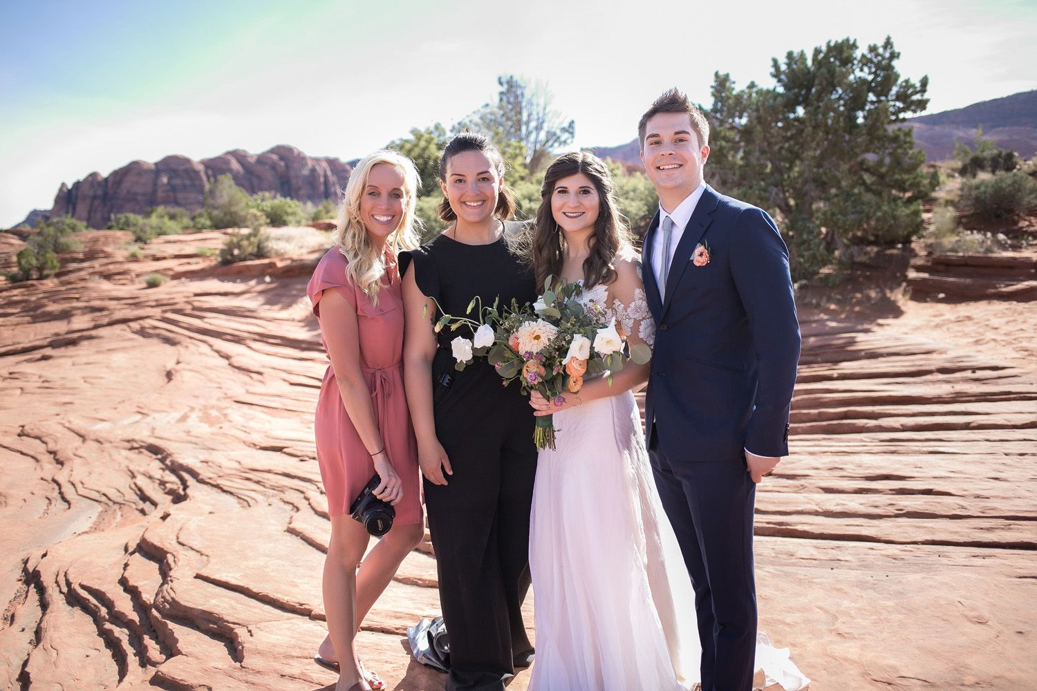 Bride and groom with their wedding photographers during southern Utah desert destination wedding.