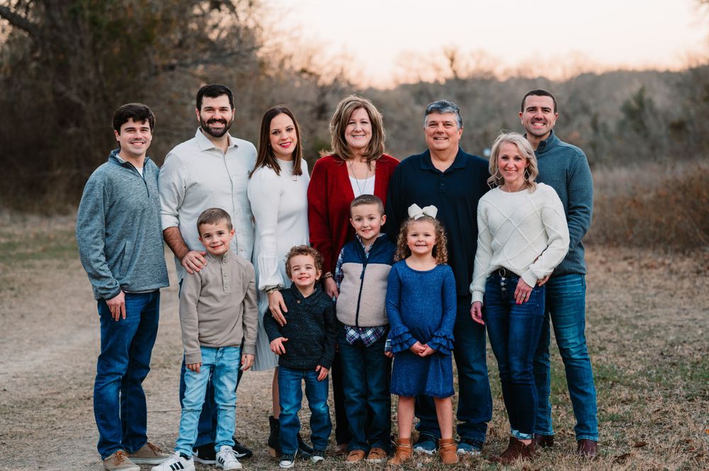 Grandparents pose with family of 11 during dallas area sunset extended family portrait session outdoors