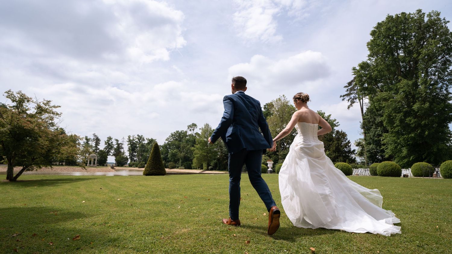 Newlyweds pose for romantic photos in an outdoor garden setting.