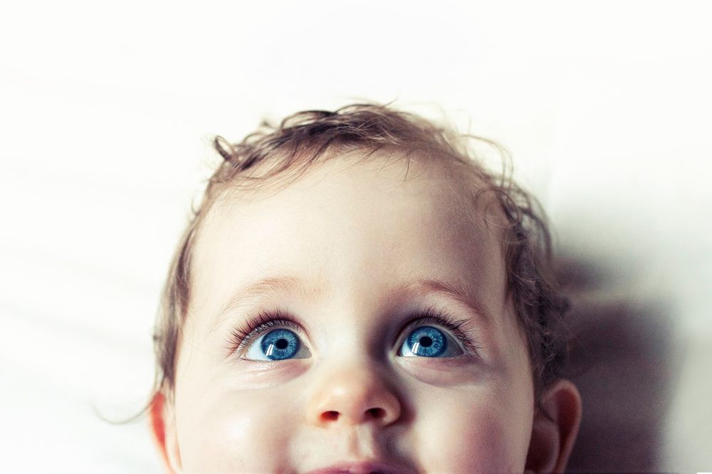 Artistic close-up portrait highlighting bright blue eyes against soft focus background.