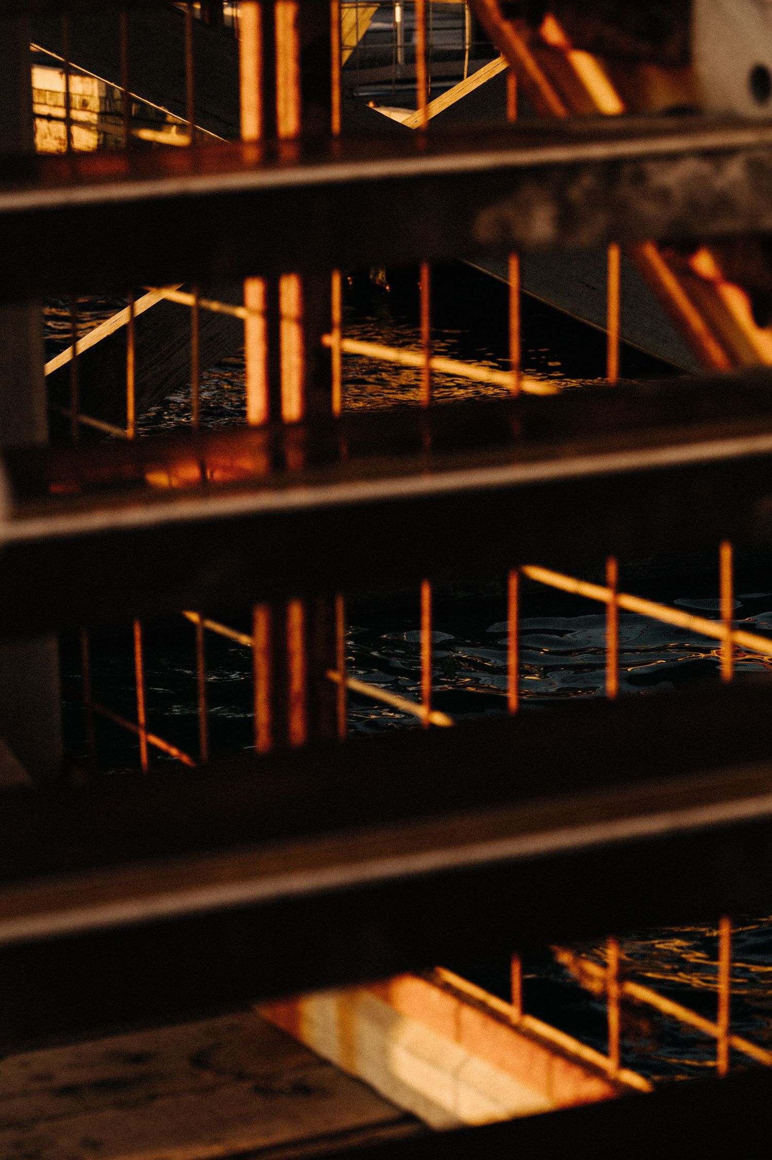 Industrial architecture with warm lighting creates geometric patterns through metal railings.